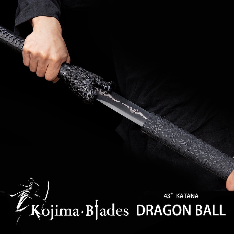 Może przedstawiać: Czarny miecz katana z rękojeścią w kształcie smoka i czarną pochwą z wzorem smoka. Miecz ma 109 cm długości i jest oznaczony jako "Kojima Blades DRAGON BALL 43" Katana".