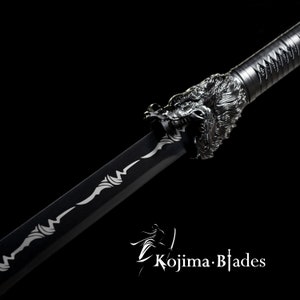 Może przedstawiać: Czarny miecz katana z srebrną głową smoka jako rękojeścią. Ostrze ma srebrny wz&oacute;r. Miecz znajduje się na czarnym tle.