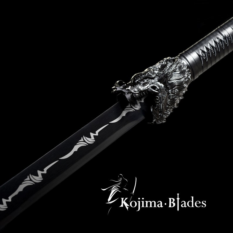 Może przedstawiać: Czarny miecz katana z srebrną głową smoka jako rękojeścią. Ostrze ma srebrny wz&oacute;r. Miecz znajduje się na czarnym tle.