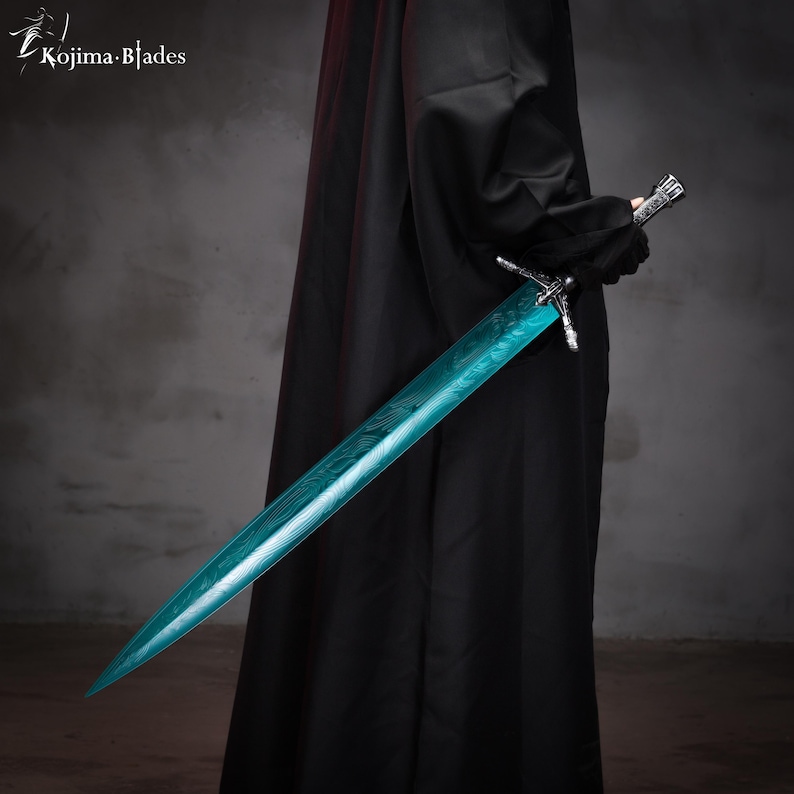 May include: A person wearing a black robe holds a teal-colored sword with a silver hilt. The sword has a detailed pattern etched into the blade.
