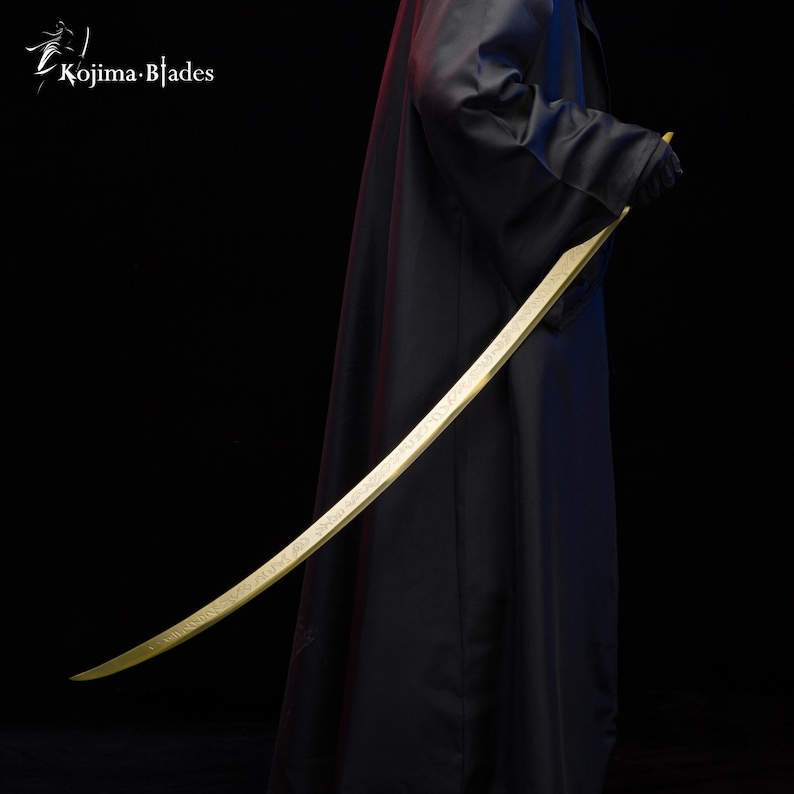 May include: A gold-coloured sword with a curved blade and intricate details. The sword is held by a person wearing a black cloak.
