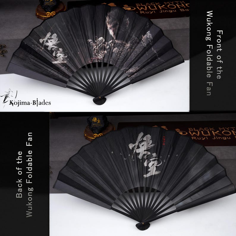 May include: Black foldable fan with a detailed illustration and Chinese characters. The fan is labeled "Wukong Foldable Fan" and features the "Kojima Blades" logo. The fan is made of black material and has a decorative design.