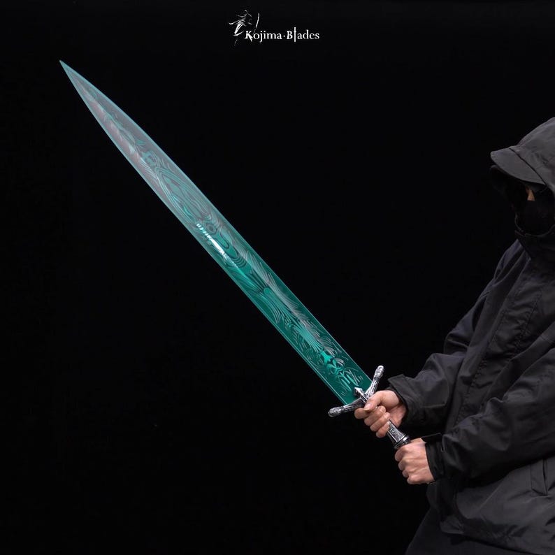 May include: A person holding a long, teal-colored sword with a silver hilt. The sword has a decorative pattern on the blade. The background is black.
