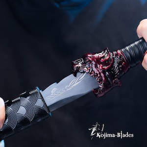 May include: A black and red sword with a dragon head handle. The sword has a black and silver patterned grip and a silver blade with a decorative design.