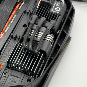 May include: Close-up of a black electric motor with a silver heatsink and a black electronic speed control (ESC) with a Spektrum logo and an on/off switch. The ESC is connected to the motor with black wires.