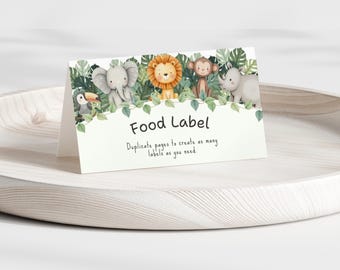 Può includere: Un'etichetta alimentare bianca e piegata con un tema della giungla. L'etichetta presenta illustrazioni di un tucano, un elefante, un leone, una scimmia e un rinoceronte, circondati da fogliame verde. Il testo "Food Label" è ben visibile.