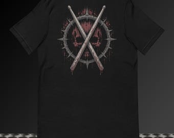 May include: A black short-sleeve t-shirt featuring a graphic on the back. The design displays two crossed drumsticks over a circular, spiked, metallic-looking frame. Behind the frame is a dark red, textured, skull-like shape with dripping effects.