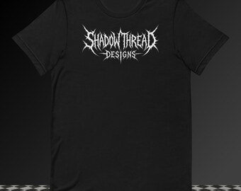 May include: A black short-sleeved t-shirt featuring a white graphic print on the chest. The design displays the text SHADOW THREAD DESIGNS in a stylized, sharp, and jagged font reminiscent of heavy metal band logos with pointed, thorn-like edges.