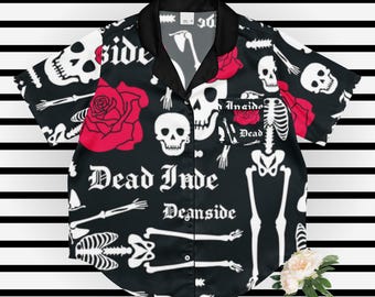 May include: Black button-up shirt with a repeating pattern of white skulls, skeletons, and red roses. The words "Dead Inside Deanside" are printed on the shirt. The shirt has a black collar and short sleeves.