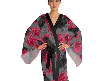 May include: A kimono-style robe featuring a repeating pattern of black crows and vibrant red roses on a gray background. The garment includes a solid black trim along the front opening and a matching black fabric tie belt at the waist.