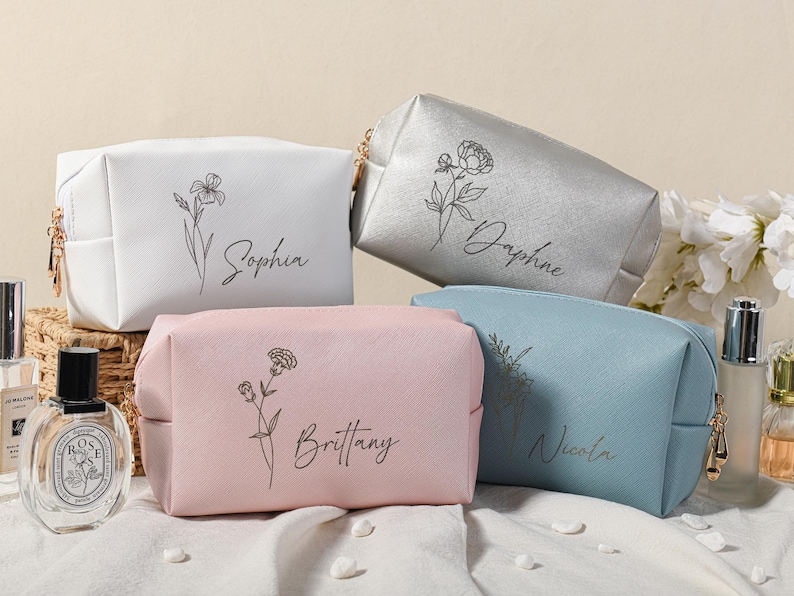Puede incluir: Cuatro neceseres personalizados con dise&ntilde;os florales y nombres: Sophia, Daphne, Brittany y Nicola. Las bolsas son de color blanco, plateado, rosa y azul.