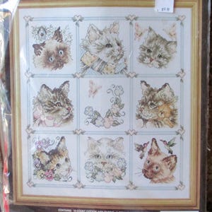 May include: A counted cross stitch pattern featuring a sampler of nine adorable cats. The pattern is titled "Cat Sampler" and is numbered #80-234. The pattern is made by Janlynn Corporation and is made in the USA.
