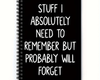 May include: Black spiral-bound notebook with white text that reads "STUFF I ABSOLUTELY NEED TO REMEMBER BUT PROBABLY WILL FORGET". The notebook has a black cover and a silver spiral binding.