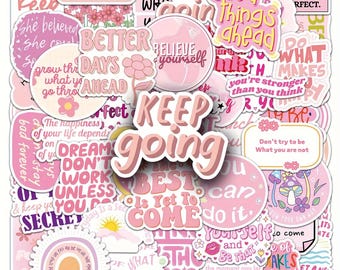 May include: A collection of pink and white stickers with motivational phrases and floral designs. The stickers feature phrases like "Keep Going," "Believe Yourself," and "Good Things Ahead." The stickers are in various shapes and sizes.