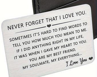 May include: A silver metal wallet card with the text "NEVER FORGET THAT I LOVE YOU." The card has a heart symbol and a message about love and friendship. The words "I Love You" are at the bottom.