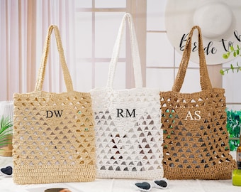 May include: Three open-weave tote bags in beige, white, and brown. Each bag has a rectangular shape with a handle and a personalized initial. The bags are made of a woven material, perfect for carrying items.