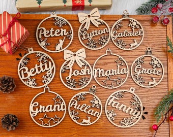 May include: Wooden Christmas ornaments with names like Peter, Betty, and Josh. Each ornament is a circle with a name cut out, along with snowflakes, stars, or a deer. Some ornaments have a bow. A festive holiday decoration.