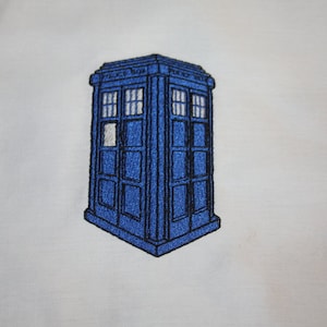 May include: Blue and white embroidered patch of a police box with the text "Police Box" on the side.