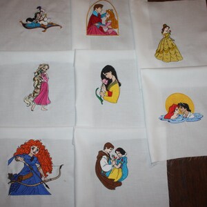 May include: Set of 8 embroidered white fabric squares featuring Disney princess couples. Each square features a different princess couple, including Ariel and Eric, Belle and Beast, Cinderella and Prince Charming, Jasmine and Aladdin, Mulan and Shang, Pocahontas and John Smith, Rapunzel and Flynn Rider, and Snow White and Prince Charming.