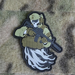 May include: A black and white patch depicting a skeleton soldier wearing a helmet and tactical gear, holding a rifle. The soldier is surrounded by a white and gray smoke-like effect.