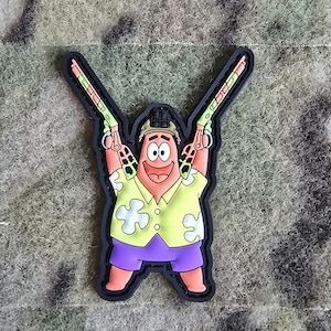 Könnte beinhalten: Eine Comicfigur trägt ein gelbes Hemd mit grünen Blumen und eine lila Shorts und hält in jeder Hand zwei grüne und schwarze Pistolen. Die Figur lächelt und hat ein rosafarbenes Gesicht. Der Hintergrund ist ein Tarnmuster.