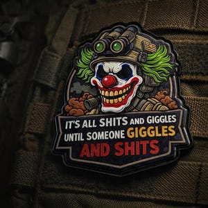Puede incluir: Parche con un payaso amenazante con una nariz roja, pelo verde y un casco militar con gafas de visión nocturna. El texto en el parche dice: "IT'S ALL SHITS AND GIGGLES UNTIL SOMEONE GIGGLES AND SHITS."