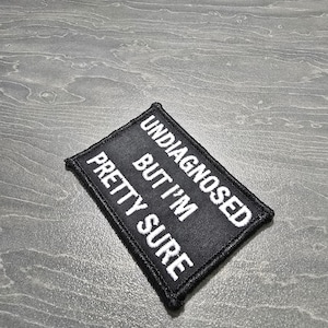 Peut inclure: Écusson brodé noir avec du texte blanc qui dit "Non diagnostiqué mais j'en suis assez sûr".