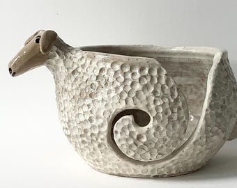 A sheep's yarn bowl made of stoneware clay. A must-have for wool enthusiasts. The wool pot is cream-white, like a white sheep.