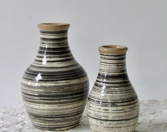 Two small bottle vases in black and white design with striped decor.