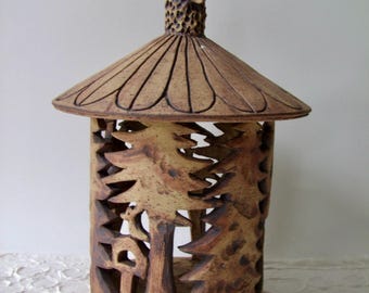 A great lantern with forest decoration and a small owl on the roof, for a small pillar candle, grave light or large tea light.