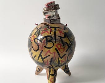 A ceramic money box for book lovers. This money box is also a small work of art, a unique piece. It is 25 cm tall.