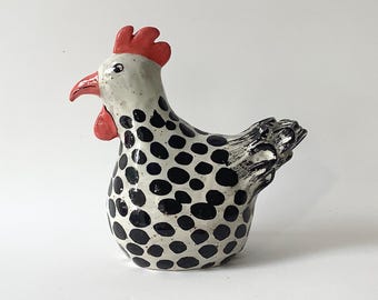 An attractive chicken made of frost-resistant clay. It is black and white and measures 16 cm in height and 19 cm in width.