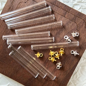 May include: A set of clear glass tubes and gold and silver metal earring findings. The tubes are various lengths and the findings are different shapes.