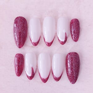May include: Set of ten false nails with a burgundy glitter finish and white tips. Some nails have a white swirl design on the tip.