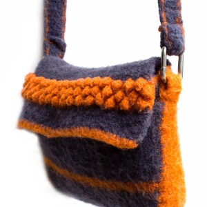 Pu&ograve; includere: Una piccola borsa a tracolla in maglia grigia e arancione con un solo cinturino. La borsa ha una chiusura a lembo e un dettaglio intrecciato sul davanti.