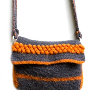 Pu&ograve; includere: Una borsa a tracolla in feltro grigio con una spessa tracolla e rifiniture in feltro arancione. La borsa ha una chiusura a lembo e una singola tasca sul davanti.