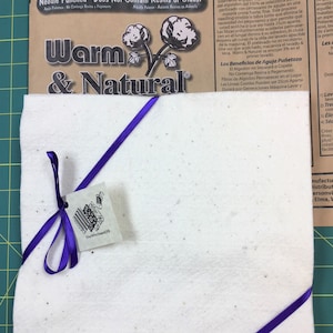 May include: A white needle-punched felt fabric square with a purple ribbon tied around it. The fabric is labeled "Warm & Natural" and says "Needle Punched - Does Not Contain Resins or Glues!"