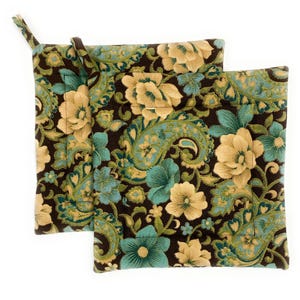 May include: Two floral patterned oven mitts. The mitts feature a dark brown background with a repeating pattern of large flowers in shades of teal, tan, and green. One mitt has a loop for hanging.