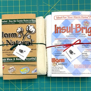 May include: Two rolls of white batting, one labeled "Warm & Natural" and the other "Insul-Bright." Both are tied with ribbon and include tags. The "Warm & Natural" roll is in a brown paper wrapper. The "Insul-Bright" roll has a blue and white checkered wrapper.