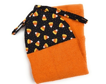 Maíz dulce de Halloween naranja y amarillo sobre corbatas negras que se quedan quietas en la cocina, el baño, el lazo para colgar, la toalla de mano para platos, la que cose