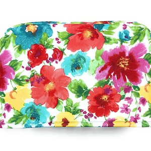 May include: A white toaster cover with a floral pattern featuring red, pink, yellow, blue, and green flowers.