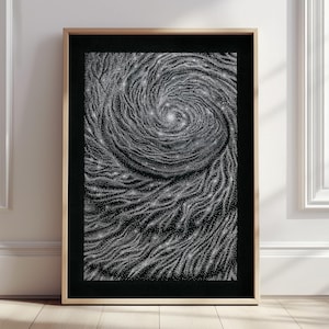 May include: A black and white framed print of a swirling galaxy with a white centre. The galaxy is made up of thousands of tiny white dots.
