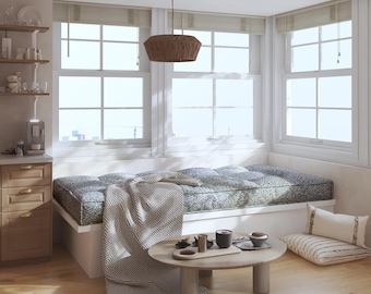 May include: A window seat with a dark patterned cushion and a grey herringbone throw blanket. A round wooden coffee table sits in front with a wooden tray, a dark mug, and a small bowl. Two rectangular throw pillows rest on the floor nearby.