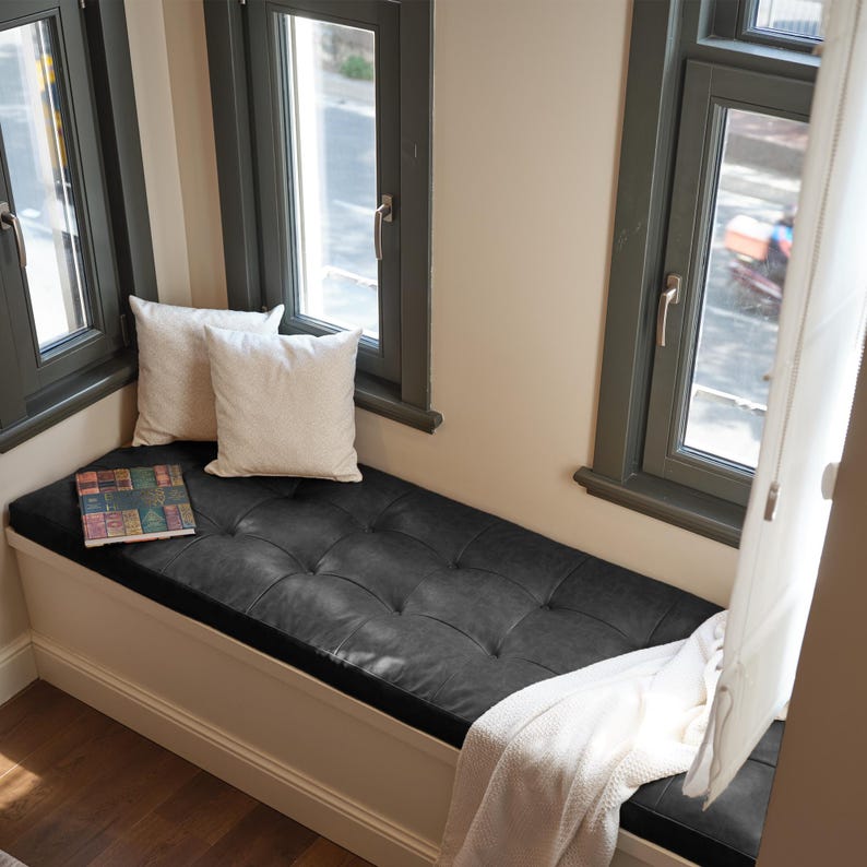 Comfortable leather floor cushion arranged in a cozy reading corner with soft rugs and warm lighting.