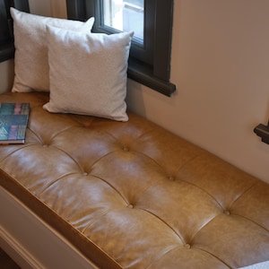 Custom leather bench seat cushion displayed in an entryway with rustic wooden details and soft light.