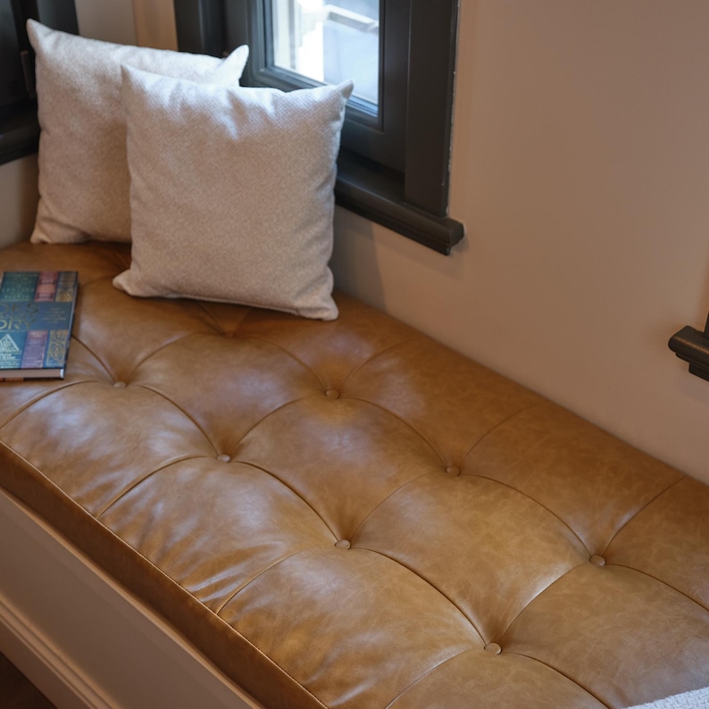 Custom leather bench seat cushion displayed in an entryway with rustic wooden details and soft light.