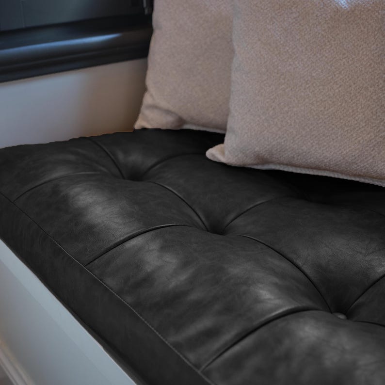 Custom leather bench cushion displayed on a wooden indoor bench with elegant minimalist décor.