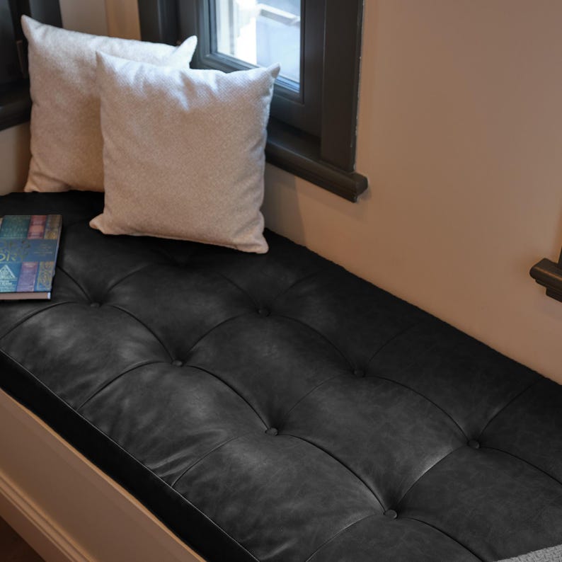 Elegant custom bench cushion displayed on a window seat surrounded by soft textiles and wooden accents.