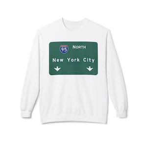 Könnte beinhalten: Weißes Sweatshirt mit einem grünen Schilder-Grafik. Das Schild zeigt "I-95 North New York City" mit Richtungspfeilen und dem I-95-Schildlogo in einem blauen Kreis.
