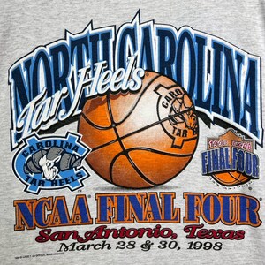 May include: A gray t-shirt featuring the words "North Carolina Tar Heels" in blue and white, along with a basketball graphic. The shirt also displays "NCAA Final Four" and "San Antonio, Texas, March 28 & 30, 1998."